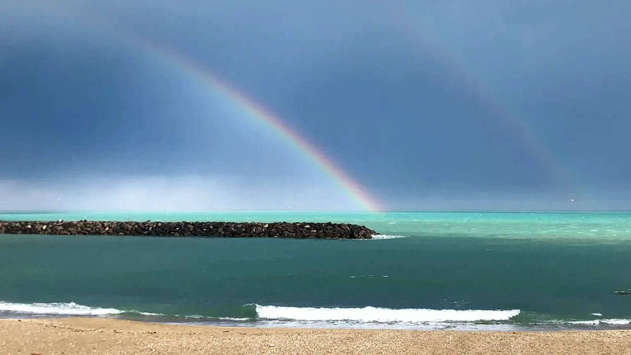 Arc-en-ciel sur la mer turquoise et la digue